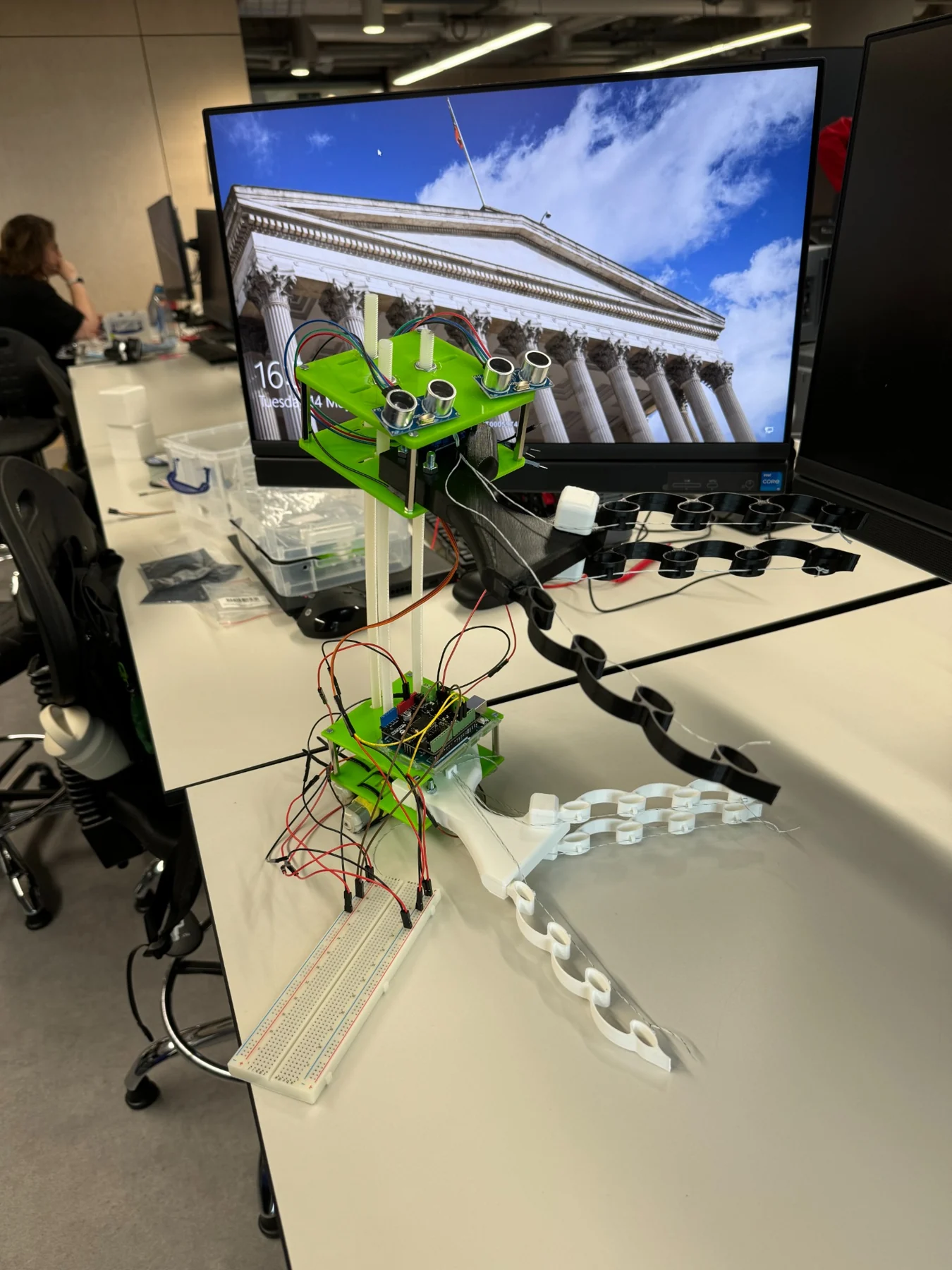 Assembled tree-climbing robot with two compliant grippers, vertical rods and electronics.
